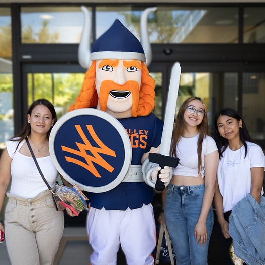 three female students with school mascot